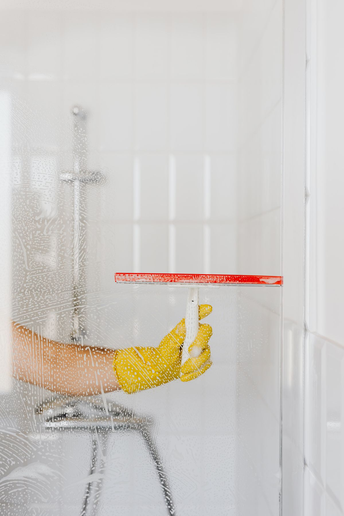 Cleaner using a squeegee on soapy glass